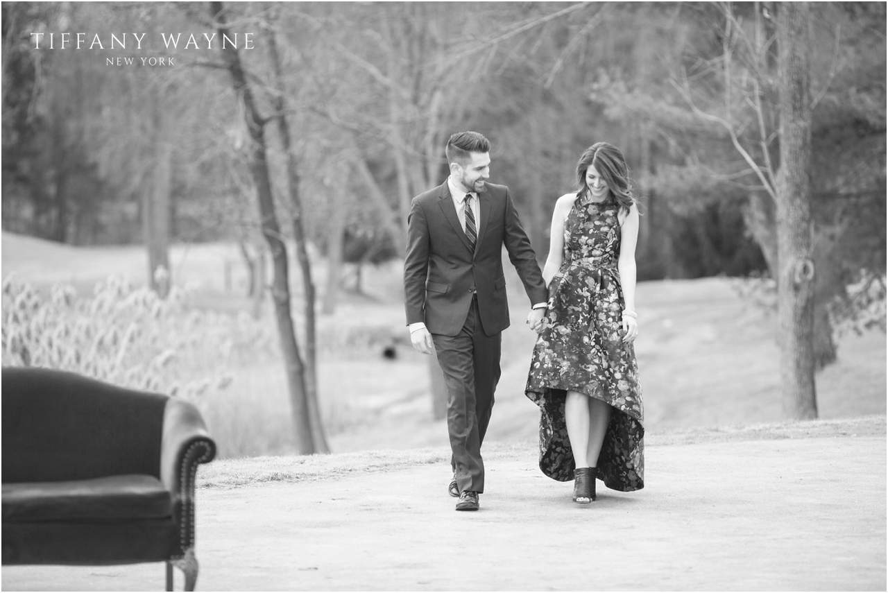 couple walks during engagement session featuring vintage sofa