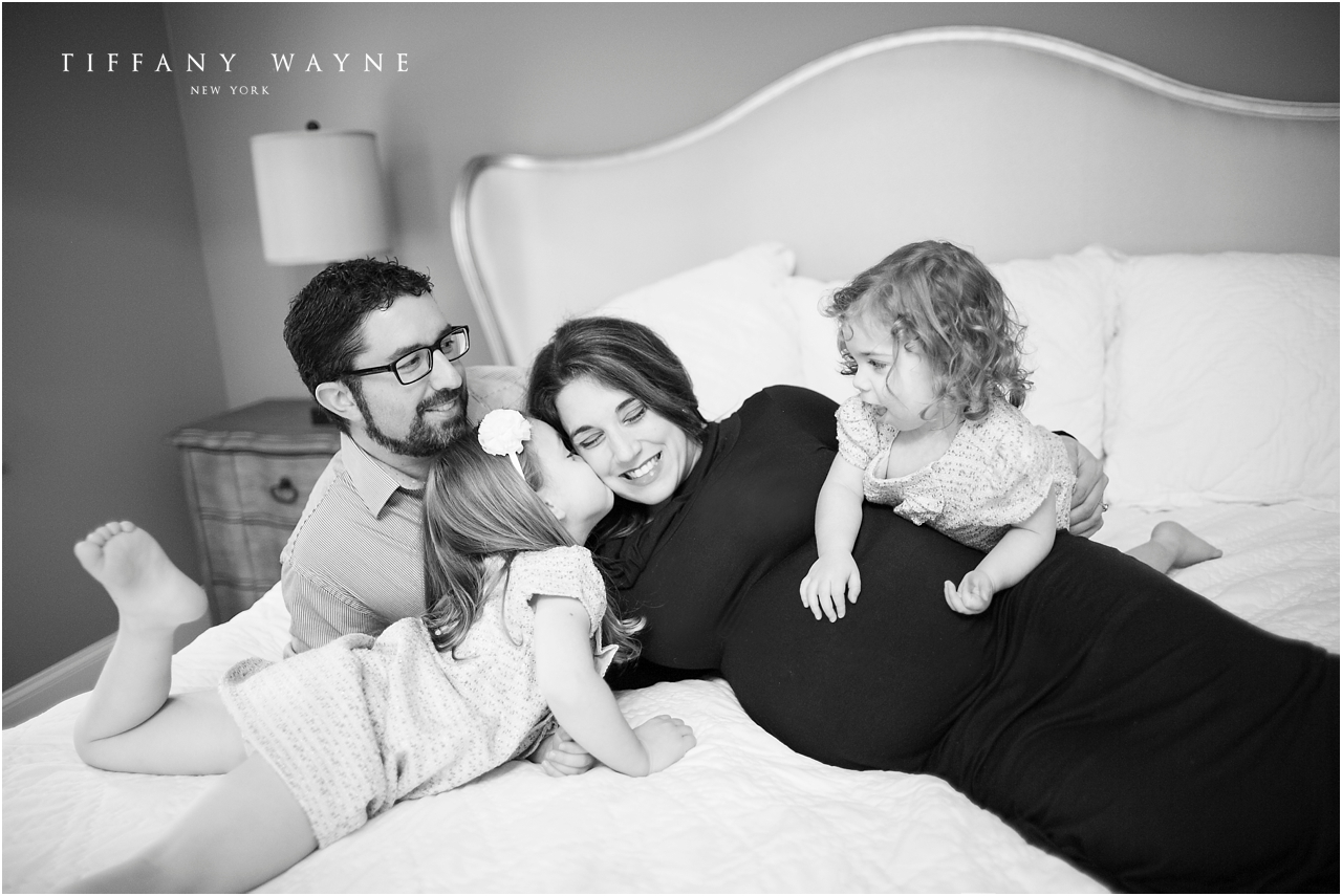 Lifestyle maternity session family laughing on bed