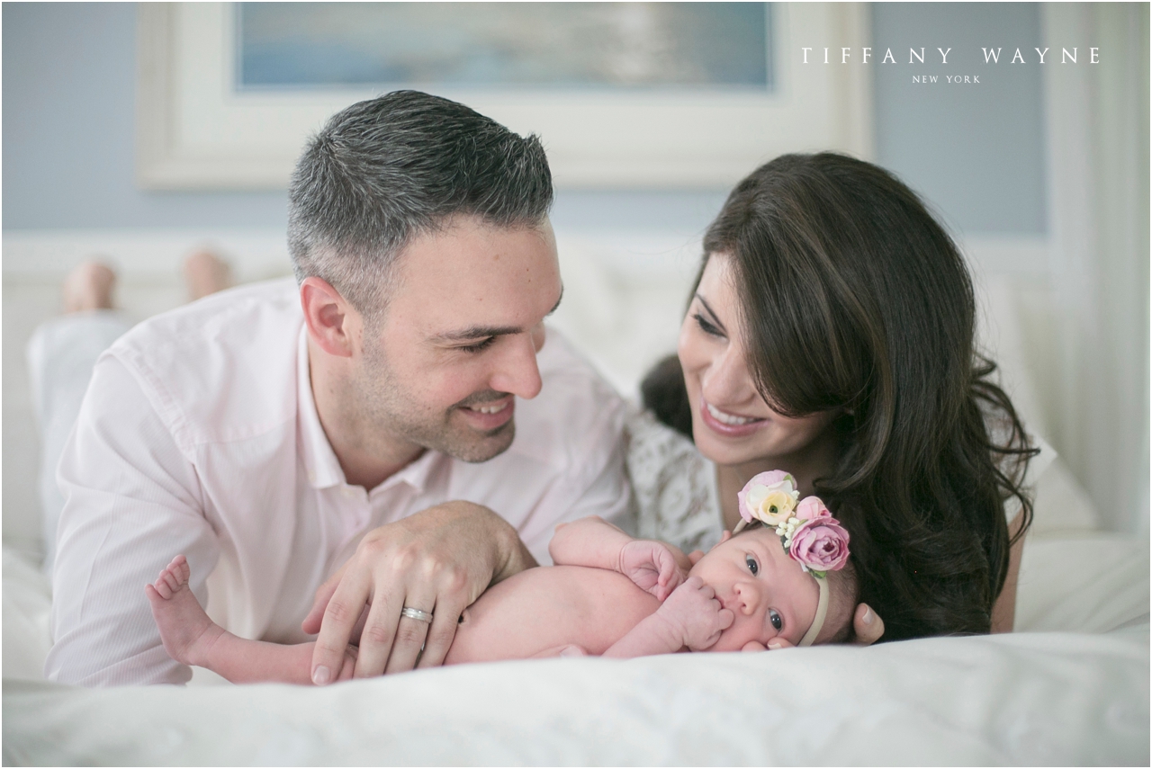 baby girl laying with parents during lifestyle newborn session