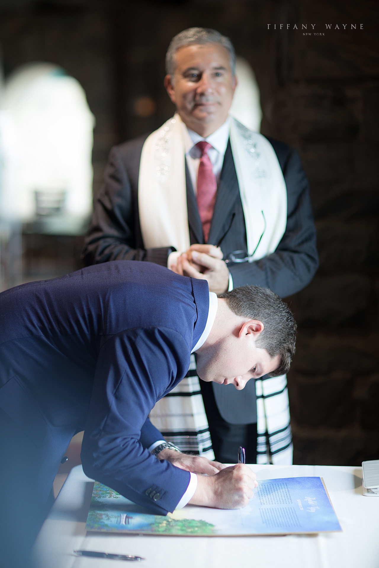 Rabbi watches groom sign license by wedding photographer Tiffany Wayne