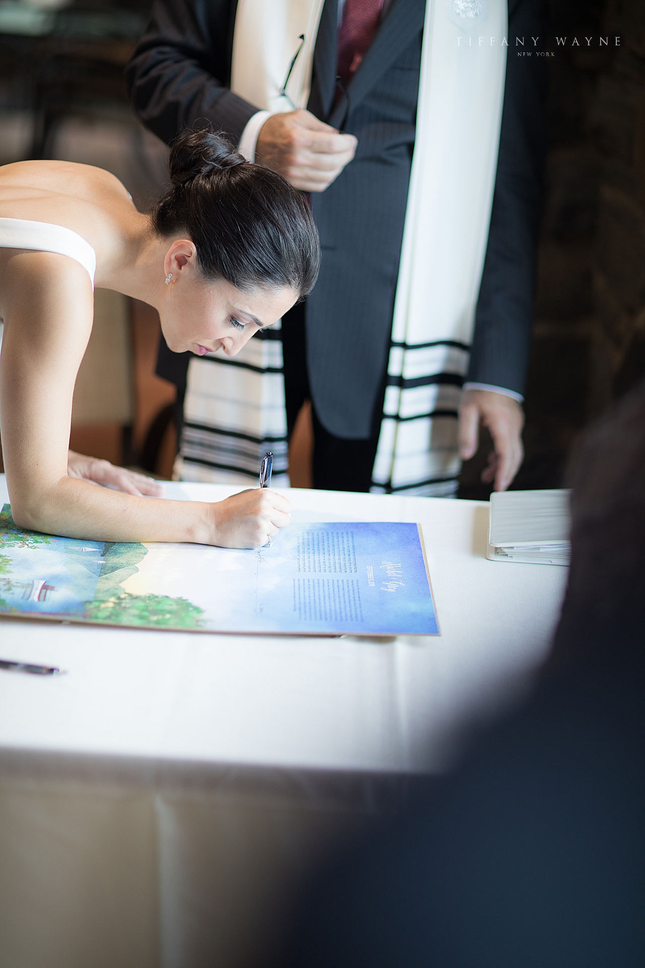 bride signs wedding license during ceremony photographed by wedding photographer Tiffany Wayne