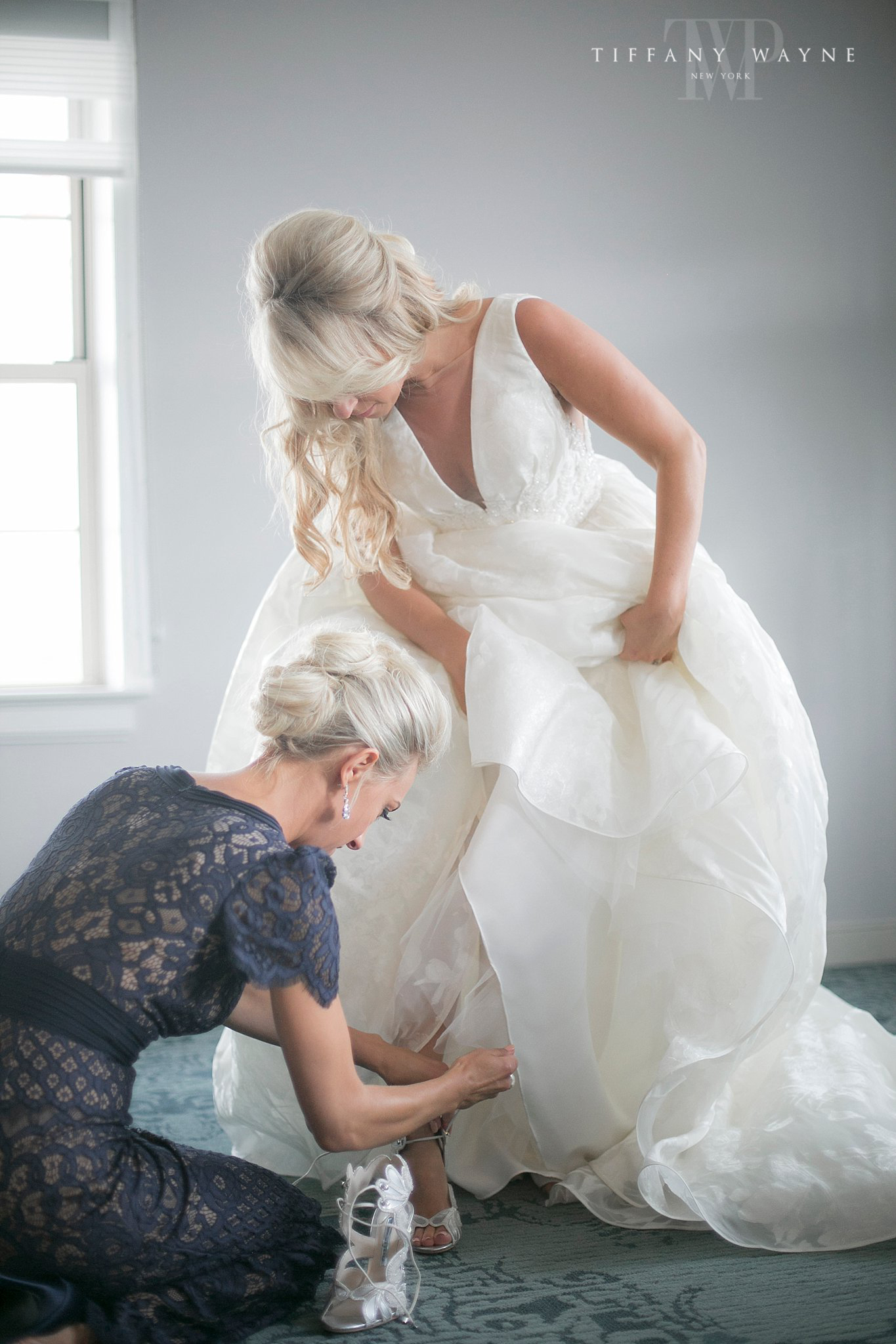 bride gets shoes on before Albany Ny wedding day photographed by Tiffany Wayne Photography