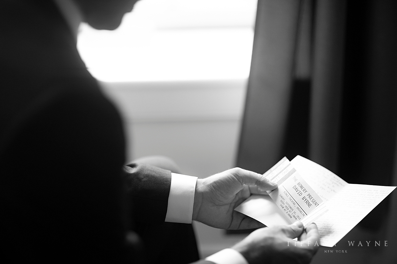 groom reads card photographed by New York wedding photographer Tiffany Wayne