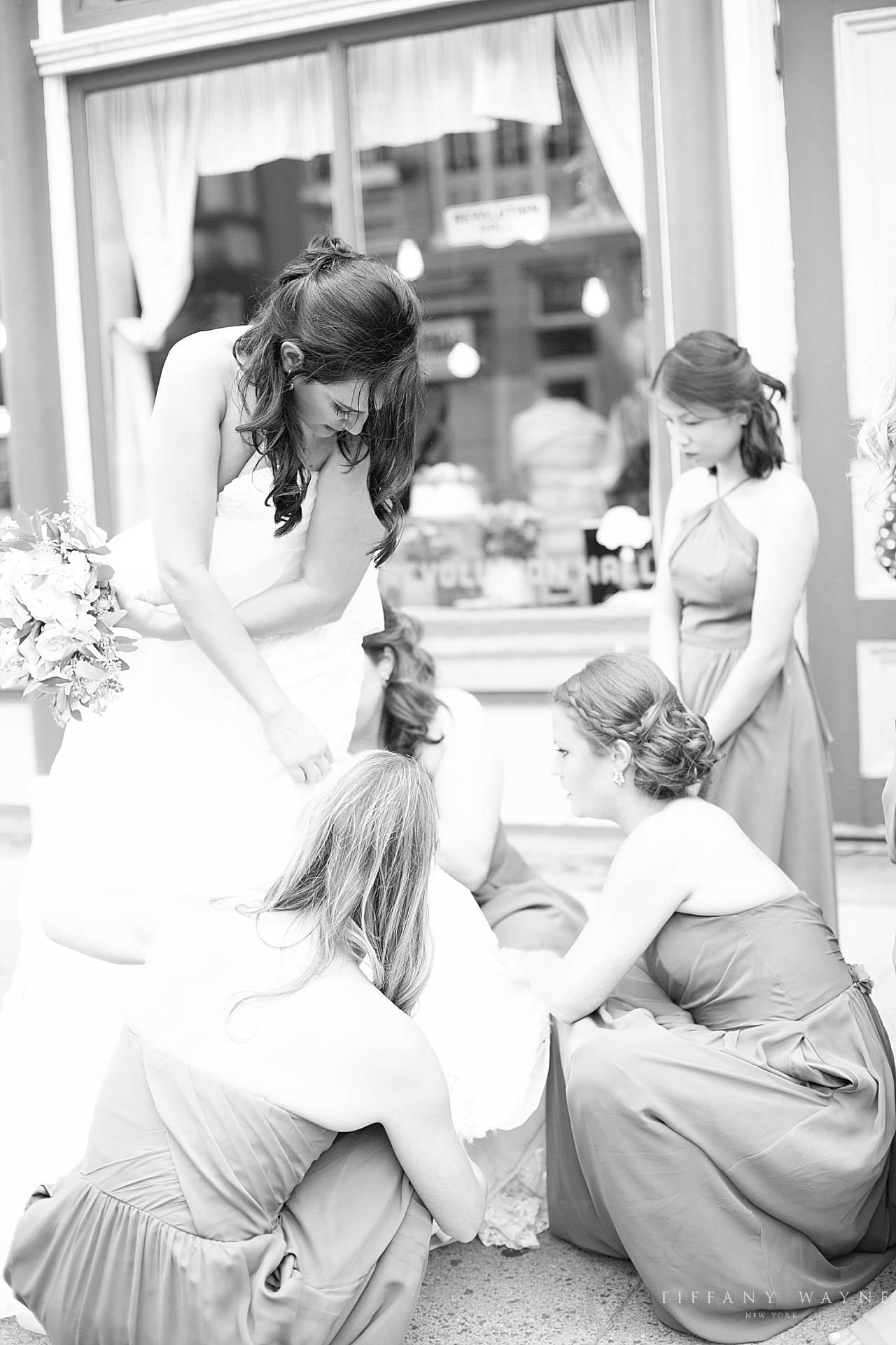 bridesmaids adjust bride's gown before reception photographed by wedding photographer Tiffany Wayne