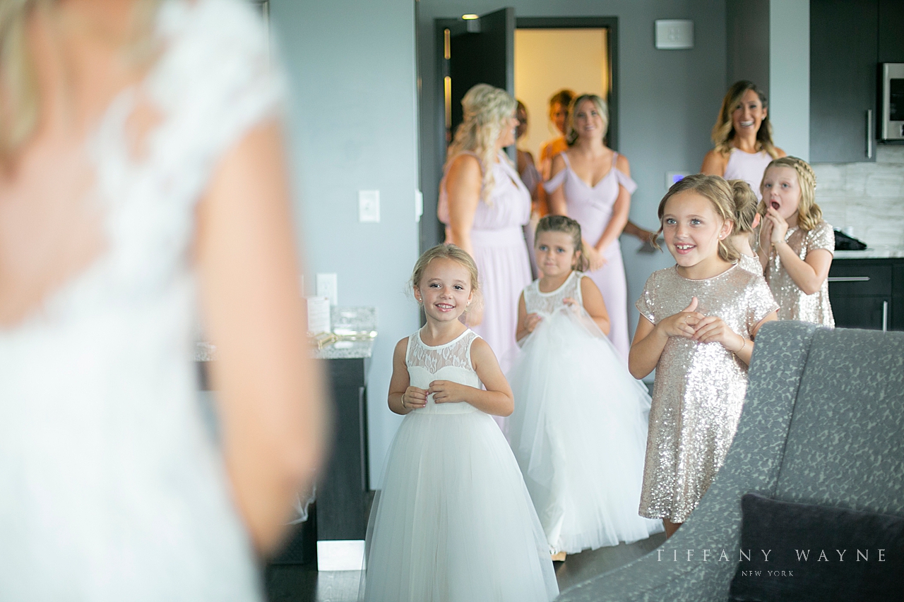 flower girls look at bride photographed by wedding photographer Tiffany Wayne Photography