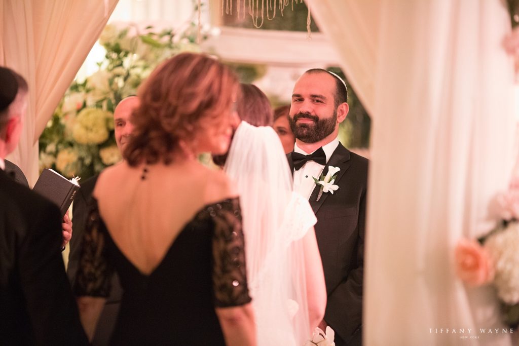 groom smiles at bride during ceremony photographed by Tiffany Wayne, New York wedding photographer