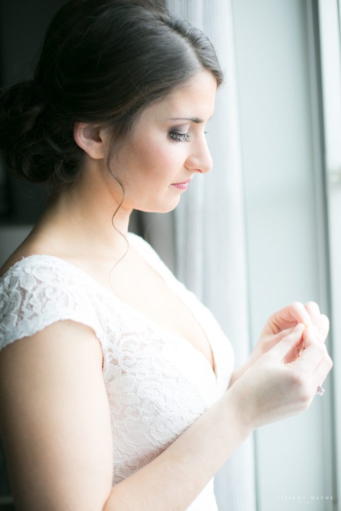 bride puts on jewelry photographed by wedding photographer Tiffany Wayne